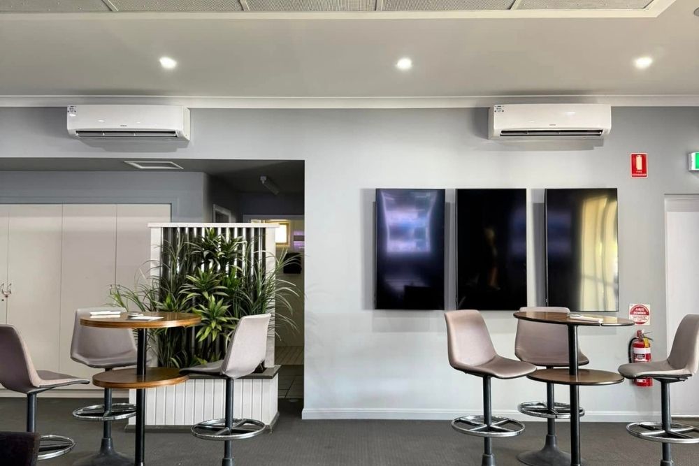 Indoor split system air conditioners mounted on a venue wall